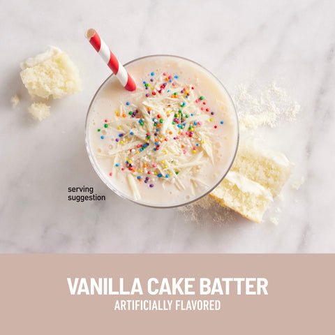 Vanilla cake batter-flavored milkshake with colorful sprinkles and a red and white straw on a marble surface.